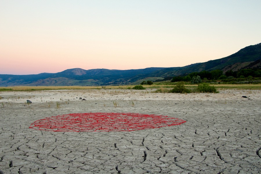Stay Together - A giant red circle of crisscrossing red string and nails creates a giant circle netting to conceptually hold down cracked earth willing drought to end. Created at Playa Summer Lake, Oregon.